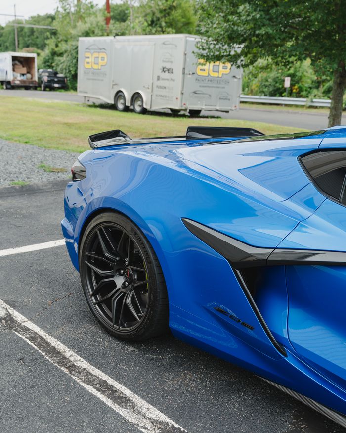 A blue Corvette from the rear three quarter with ACP trailer behind