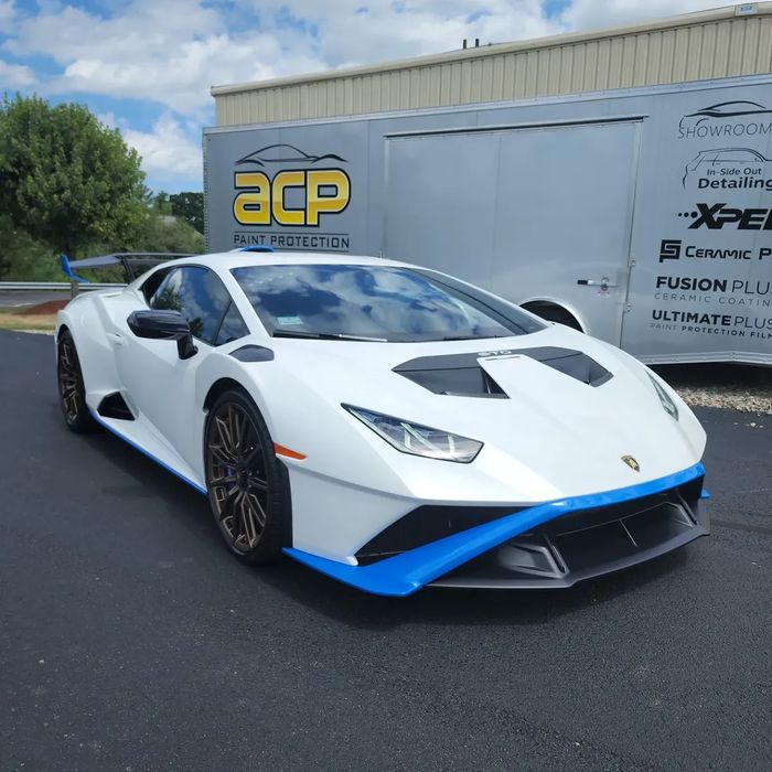 A white Lamborghini Huracán STO in front of the ACP trailer